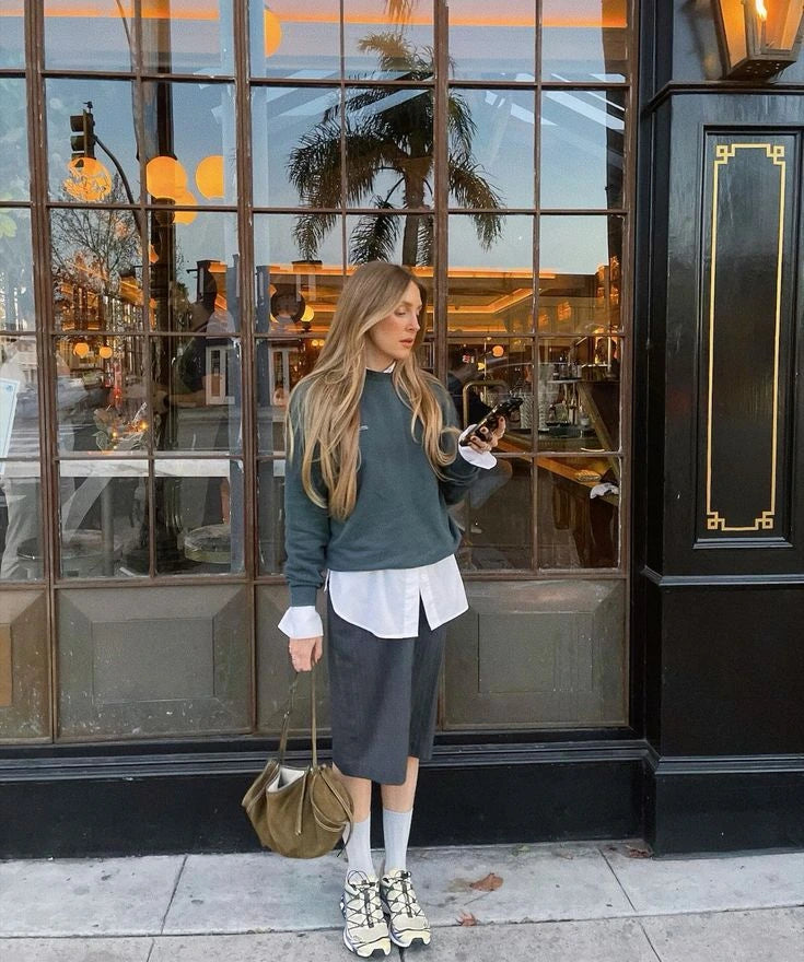 Sneakers styled with a sweatshirt and midi skirt